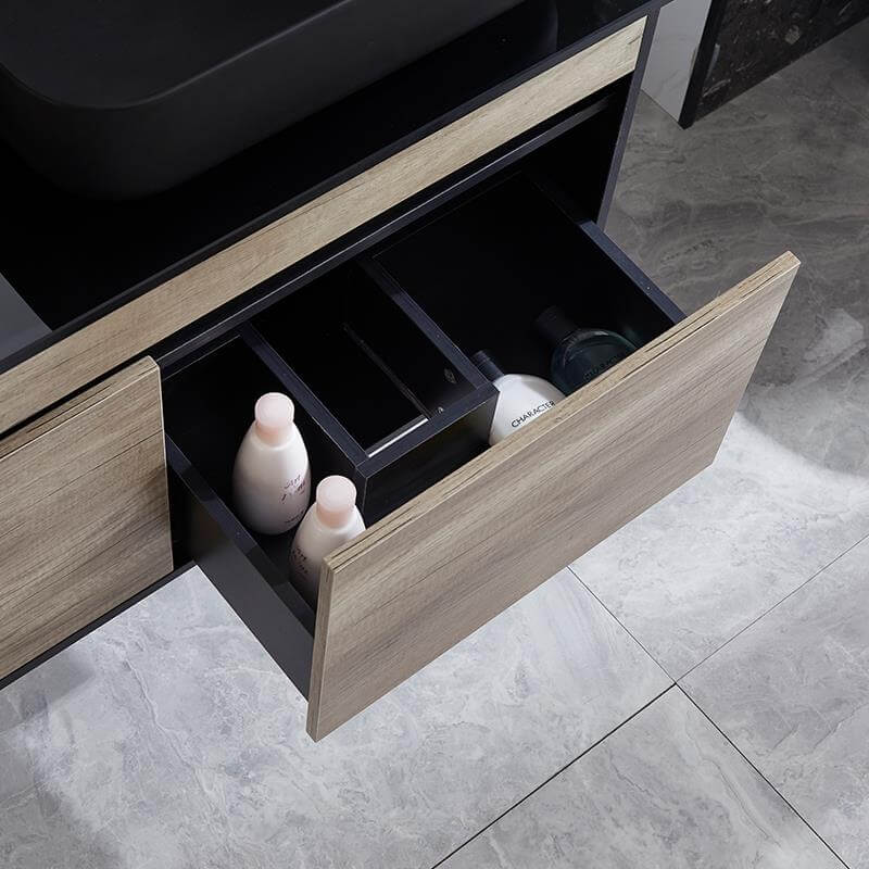 Detalle del cajón frontal en negro del mueble Vesta, diseñado para maximizar la organización en el baño