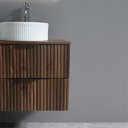 Detalle de acabado nogal en mueble de baño suspendido con lavabo sobre encimera