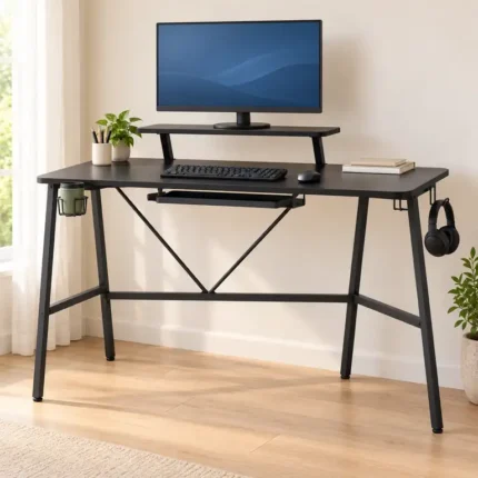 Mesa gaming negra con soporte elevado para monitor en una zona de juego y estudio luminosa.
